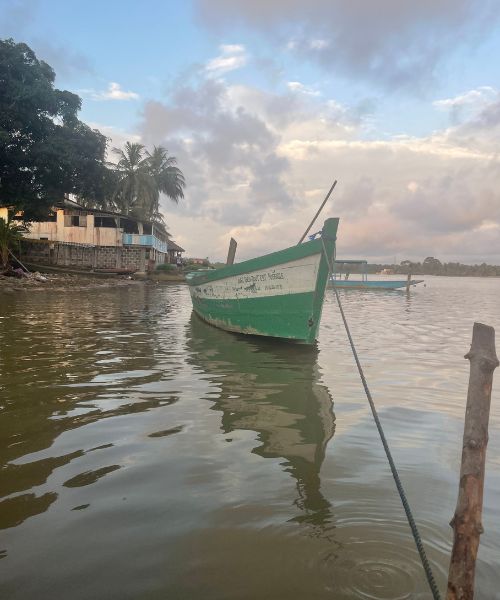 A pirogue, or small wooden boat, sits ready for passengers in the lagoon of Assinie, Côte d'Ivoire.