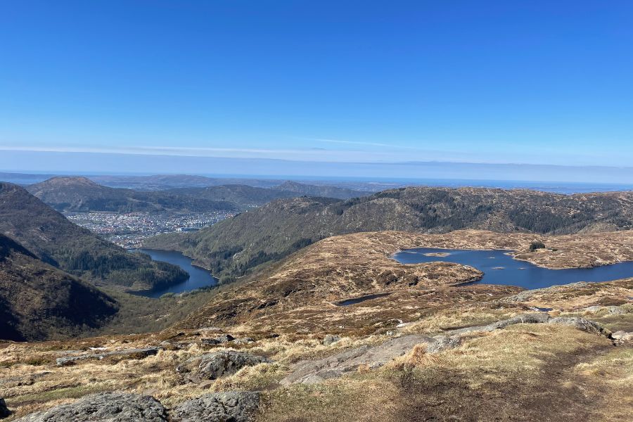 Panoramic views over several small lakes and the city of bergen which can be seen from the Norway Hiking Vidden Route