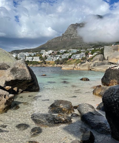 Clear blue water and large rocks form the beach at Beta Beach in Cape Town.