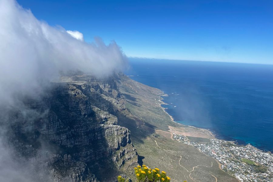 Clouds blow across a panoramic view over the ocean on the top of Table Mountain in Cape Town.