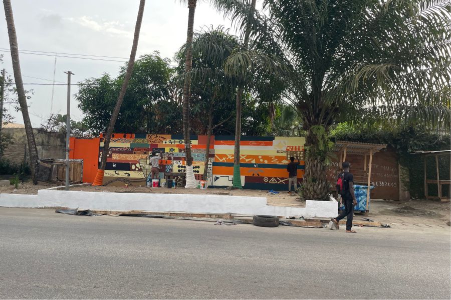 A man paints a colorful patterned mural in Zone 4, a neighborhood in Abidjan, Côte d'Ivoire.