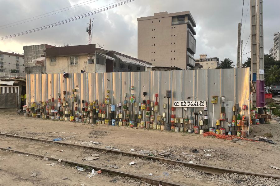 Colorful stacked tin cans form artwork along a railroad in Zone 4, a neighborhood in Abidjan, Côte d'Ivoire.