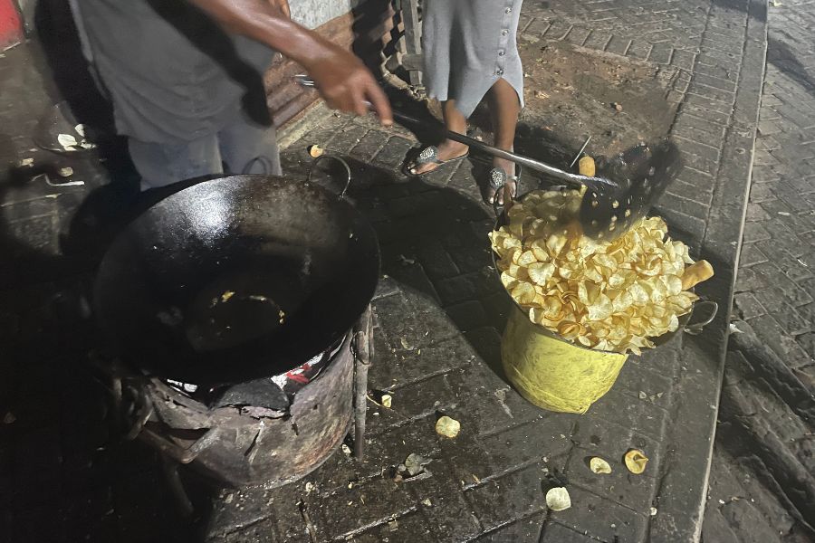 A street vendor scoops fried cassava crisps out of boiling oil in Mombasa.