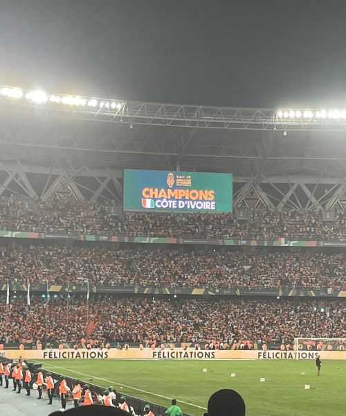 A jumbotron screen displays the message "Champions Côte d'Ivoire" in a football stadium in Abidjan after Côte d'Ivoire's win of the 2024 AFCON tournament.