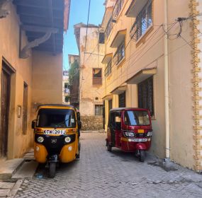 Two tuk-tuks sit in the streets of Mombasa's Old Town, part of the port city on the coast of Kenya