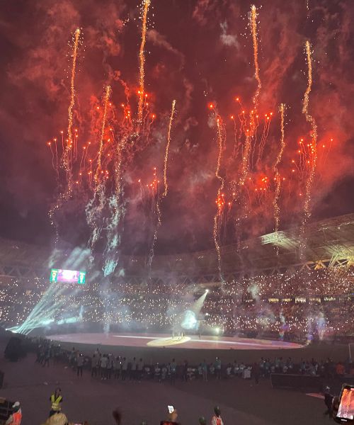 Red-orange fireworks are set off in a football stadium before the final match of AFCON 2024