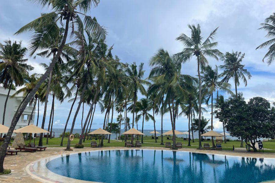 A pool surrounded by palm trees at a conference center in Shanzu, Kenya