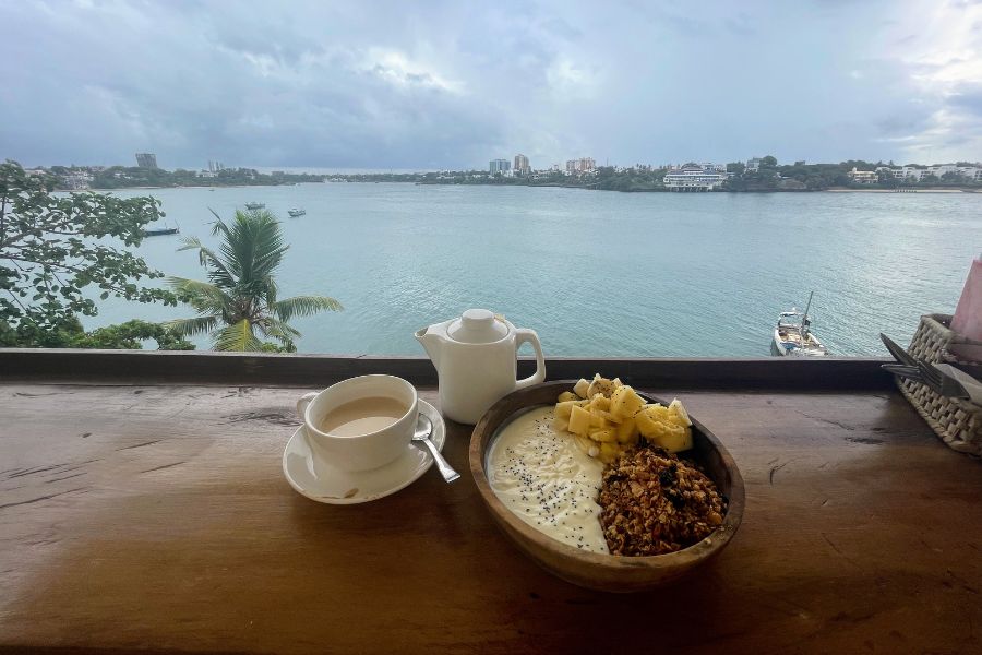 A yogurt bowl and chai breakfast at the balcony of Tulia Old Town Hostel, where you get a fantastic view over the river in Mombasa.