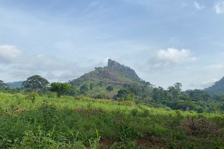 The hike to Dent de Man is lush and green, with a view of the rock formation you'll be summiting!